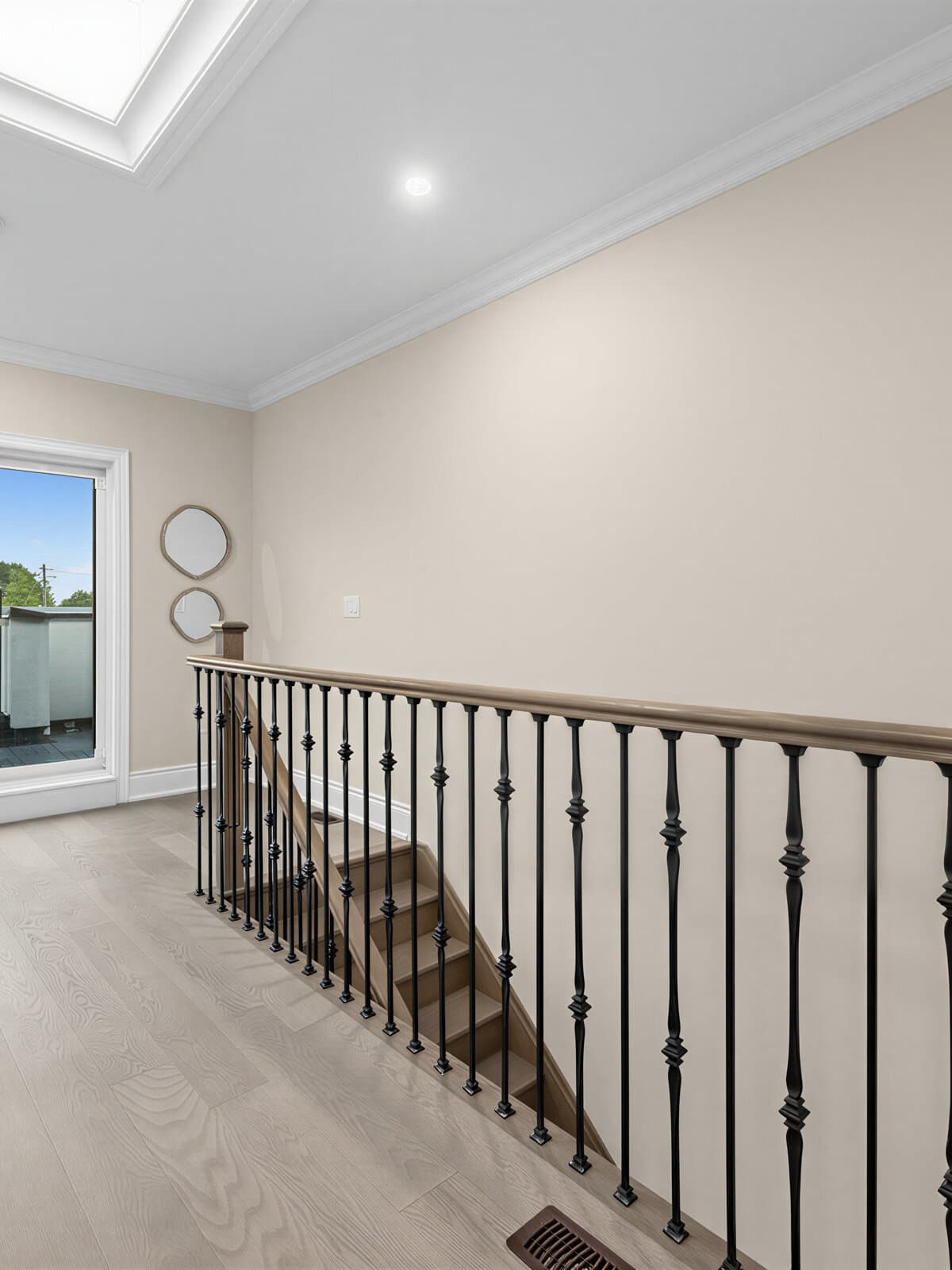 Skylit third-floor landing with iron railing